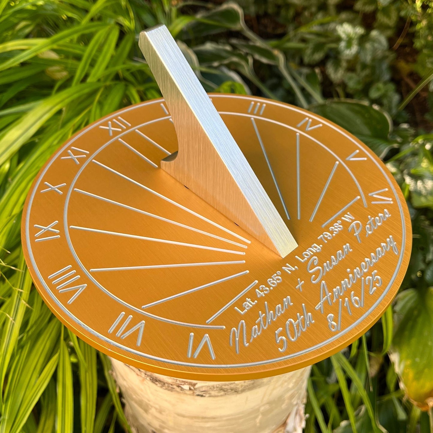 Wedding anniversary golden sundial in garden, beside flowers, displayed as a 50th wedding anniversary garden gifts sundial.