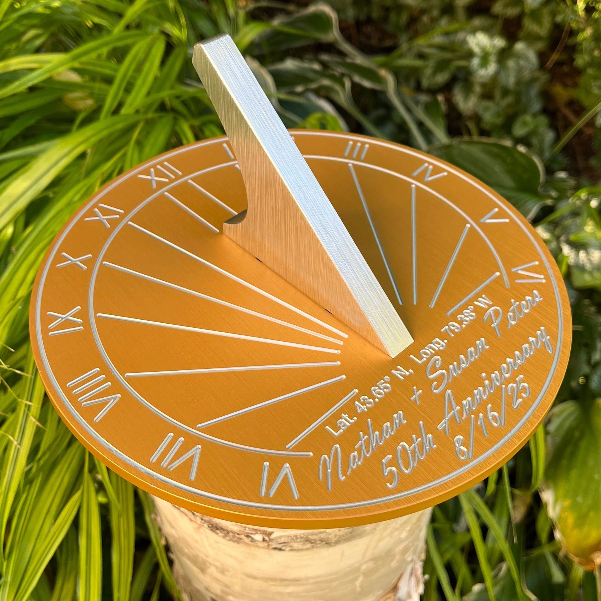Wedding anniversary golden sundial in garden, beside flowers, displayed as a 50th wedding anniversary garden gifts sundial.