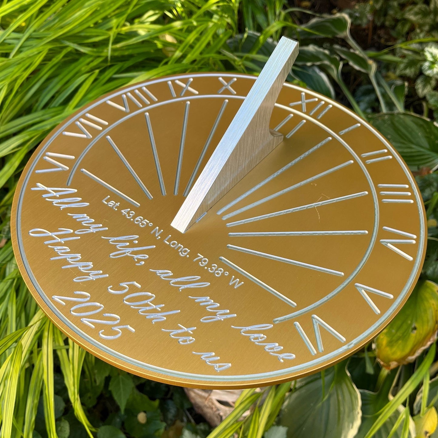 Gift suggestion for golden wedding anniversary sundial displayed in garden alongside flowers, inspiring golden wedding anniversary ideas. 
