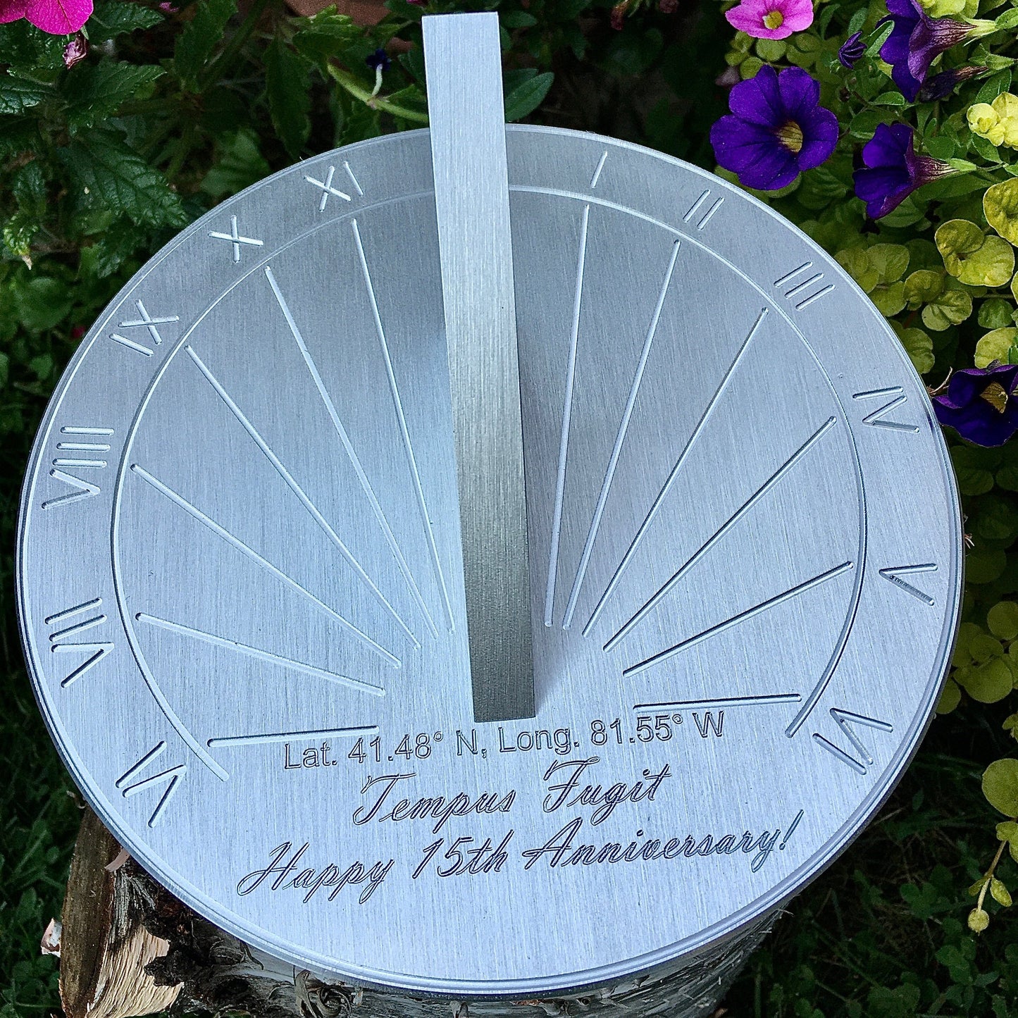 Ruby wedding anniversary gifts sundial displayed in garden by flowers as 40th wedding anniversary gifts for husband. 