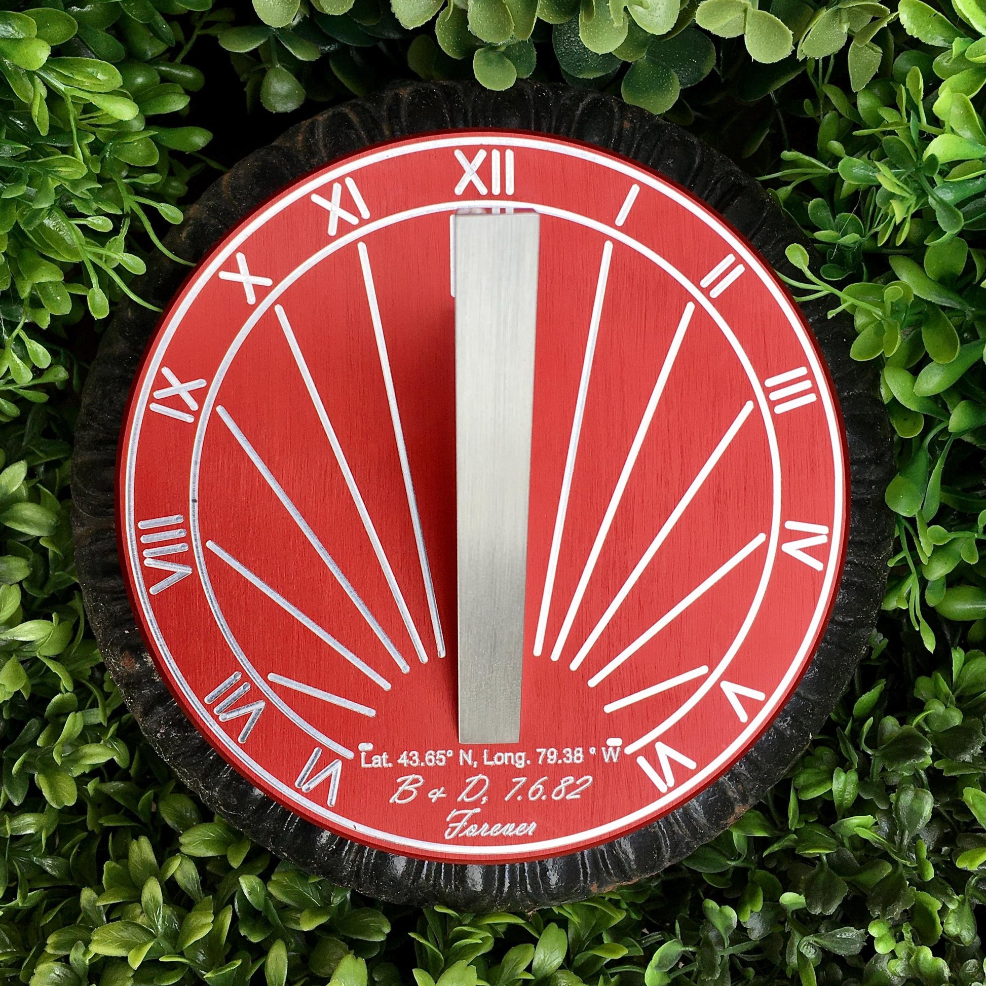 Sundial gift ideas for ruby wedding shown in garden on black flower pot, given as ruby wedding anniversary present.